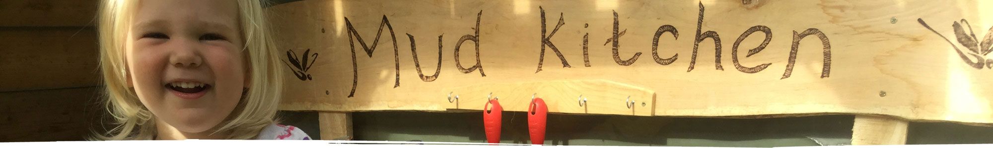 Happy girl using mud kitchen in Wrexham