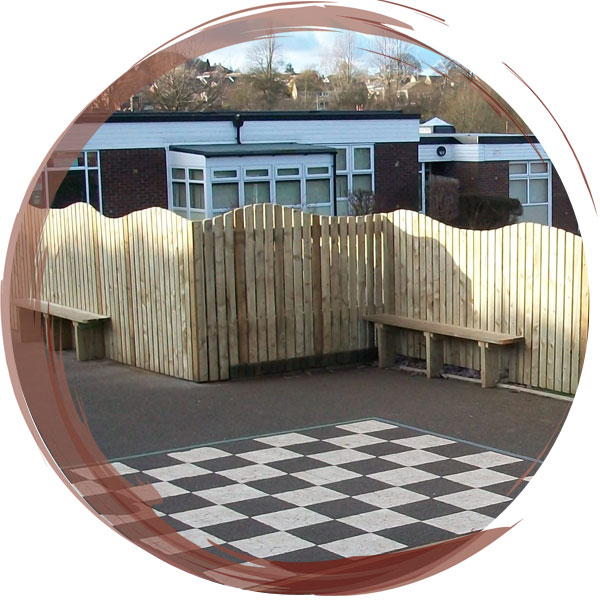 Timber fencing and seating installed to soften a hard playground and provide areas for quiet play