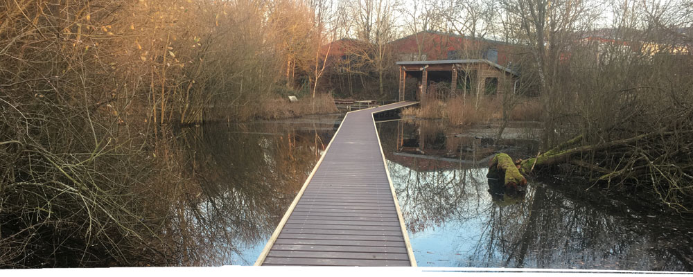 Bridge across pond to conservation hut